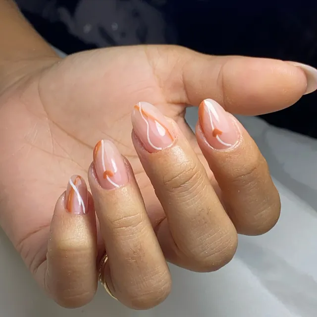 Unhas amendoadas com arte em laranja e branco